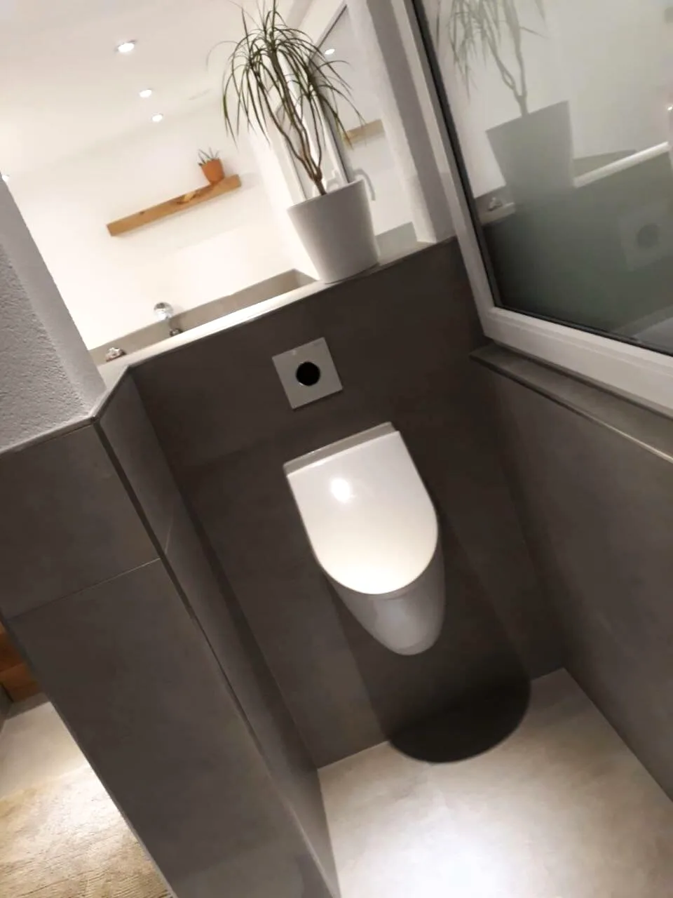 Gäste-WC mit Urinal und grauen Großformatfliesen