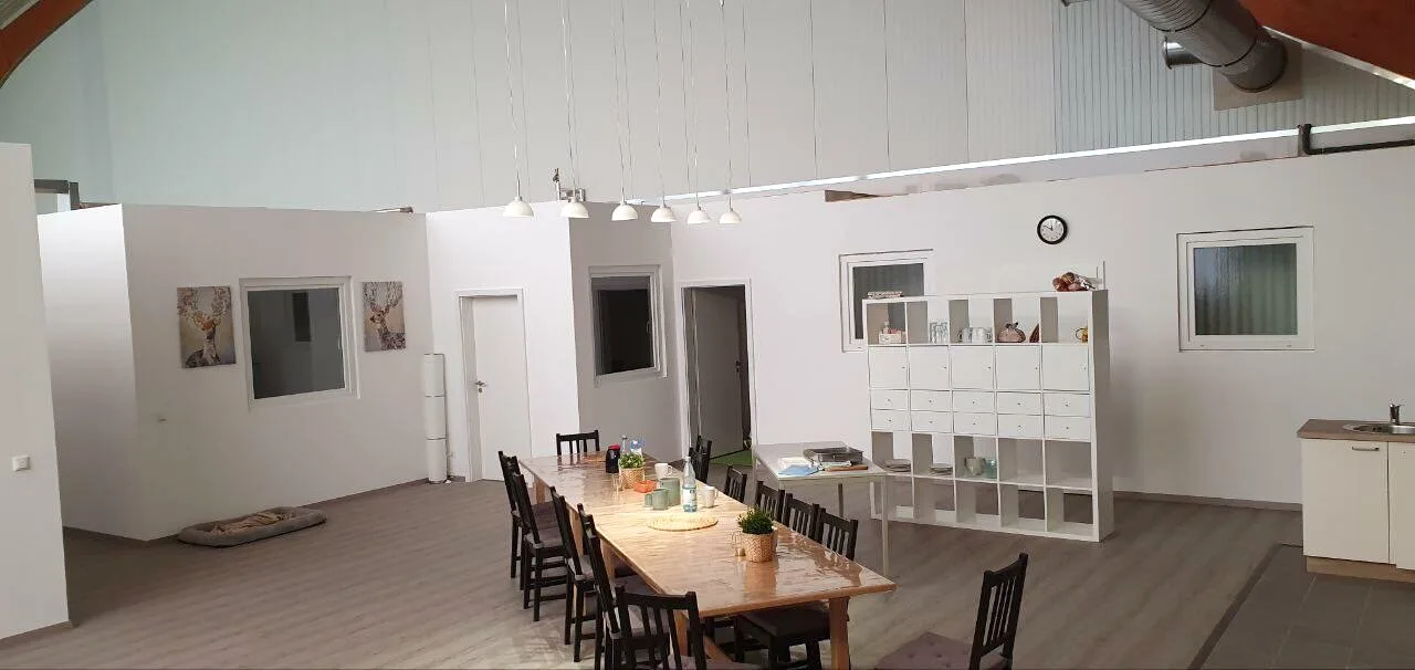 Aufenthaltsraum mit Küchenzeile und langer Tafel in Trockenbauweise